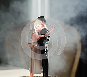 Doll wedding couple indoors is hugging each other. Beautiful model girl in white dress. Man in suit. Wedding love concept. Close u