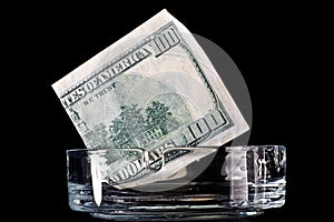 Dollar banknote in ashtray