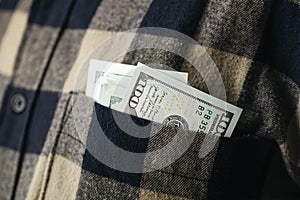 Dollar banknotes in pocket of shirt, cash payment and financial concept.