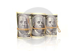 Dollar banknotes in rolls tied with craft rope.
