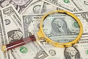 Dollar banknotes under magnifying glass