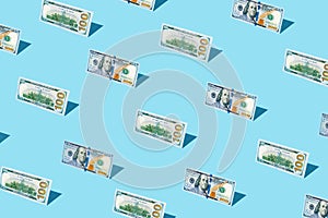 100 dollar bill izometric pattern on bright light blue background.