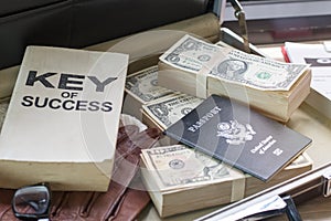 Dollar bill ,passport, business document and key of success book