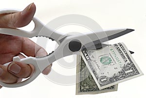 US One Dollar bill being cut with scissors