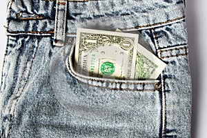 A dollar bill sticking out of a pocket of blue jeans, a credit card, and a wallet. Poverty and unemployment.