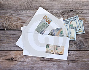 Dollar bills in closed and opened white envelopes for business bonuses, illegal salary, revenue, corruption, bribery or donation
