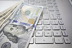 Dollar bills are placed on the keyboard of the laptop. trading concept Payments and investments in the modern era via online