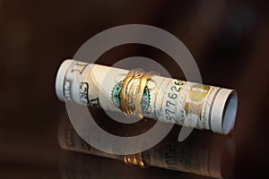 Dollar bills roll money with gold jewelry