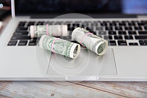 Dollar bills scattered on laptops and keyboards