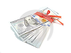 Dollar bills tied with red ribbon and decorated as a gift on a w