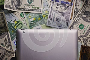 Dollar and euro money, tablet, cell phone close up.