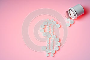 Dollar mark made by white pills spilling out of white bottle on pink background. Creative medicine for health/medical problem,