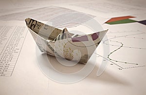 Dollar paper boat on financial data