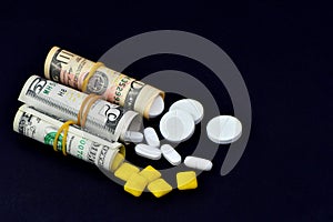 Dollar rolled up with pills flowing out isolated on black background, high costs of expensive medication concept. Copy space -
