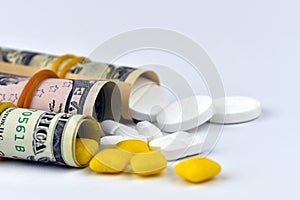 Dollar rolled up with pills flowing out isolated on white background, high costs of expensive medication concept. Copy space -