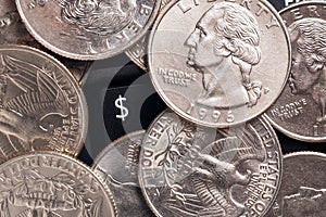 Dollar symbol. American US money quarter coins lie on a black computer or laptop keyboard around a button with a national currency