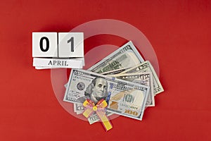 Dollar tied with a festive bow. American currency, paper currency notes. perpetual calendar with wooden cubes