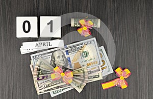 Dollar tied with a festive bow. American currency, paper currency notes. perpetual calendar with wooden cubes