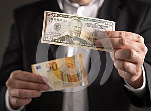 Dollar vs euro. Business man in suit holding 50 banknote