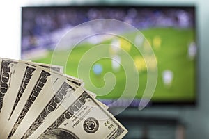 Dollars against the backdrop of a TV set for football, football and money