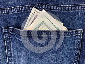 Dollars in the back pocket of men`s jeans. Banknotes of American money in blue jeans. American currency peeps out of clothes