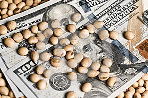 Dollars banknotes and coins and soy beans,