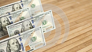 100 Dollars bill and portrait Benjamin Franklin on USA money banknote. Hundred dollar bills on wooden background