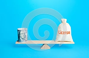 Dollars bundle and a bag with word License on scales. Estimating the value of copyrights and patents. Royalty deductions. Penalty photo