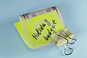 Dollars cash money in clip with text written note Holiday budget , on copy space background - concept of financial planning of set