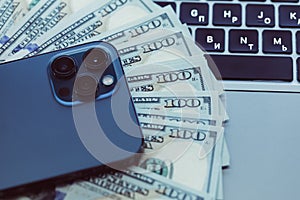 Dollars, computer tablet on mobile phone wooden background. Top view