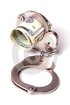 Dollars and the handcuffs on a white backgroun