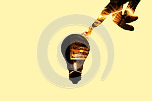 Dollars in the lamp bulb isolated on yellow background. New idea concept. Man touching money inside