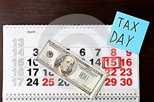 Dollars money, April 15 on calendar, sheet of paper with Tax Day
