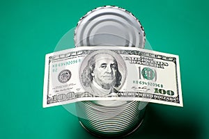 Dollars in an open tin can. Safeguarding cash, stash concept. Time to get the deferred, accumulated money. Green background