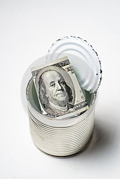 Dollars in an open tin can. Safeguarding cash, stash concept. Time to get the deferred, accumulated money. White background