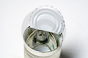 Dollars in an open tin can. Safeguarding cash, stash concept. Time to get the deferred, accumulated money. White background