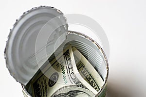 Dollars in an open tin can. Safeguarding cash, stash concept. Time to get the deferred, accumulated money. White background