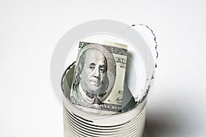 Dollars in an open tin can. Safeguarding cash, stash concept. Time to get the deferred, accumulated money. White background