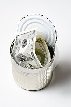 Dollars in an open tin can. Safeguarding cash, stash concept. Time to get the deferred, accumulated money. White background