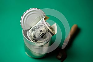 Dollars in an open tin can and a snippet. Safeguarding cash, stash concept. Time to get the deferred, accumulated money. Green