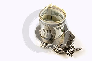 Dollars and steel handcuffs on a white background