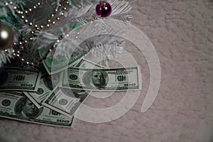 Dollars are under the New Year`s basket. Gift under the Christmas tree. Business with dollars. Pile of money on the table.