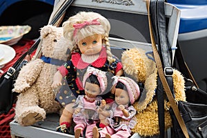 Dolls and teddies in a stroller at a flea market stall