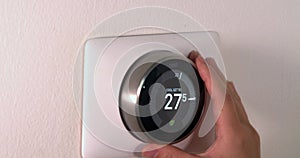 Dolly of a person saving energy during summer high temperatures on centigrade celsius metrics using a Nest smart thermostat on a w