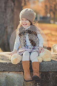 Dolly pin-up toothsome young brunette girl wearing fashion stylish gray jacket jerkin and warm hat with awesome boots clothes posi photo