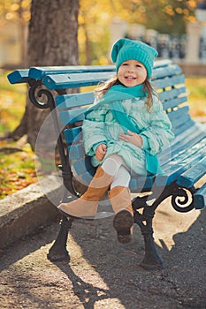 Dolly pin-up toothsome young girl wearing turquoise light blue jacket and warm hat fashion stylish clothes posing in autumn spring photo