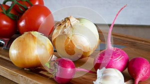 Dolly. Radish onion tomato knife and other vegetables on a kitchen board
