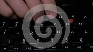 Dolly shot of hacker hands typing, black keyboard