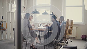 Dolly shot of teamwork at loft modern office table. Multiethnic business people cooperate, discuss market at meeting 4K.