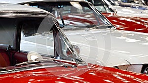 Dolly shot of vintage retro car hoods painted in red and white. Old transport exhibition or auction